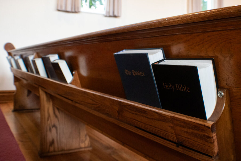 psalter and Holy Bible in wooden church pew